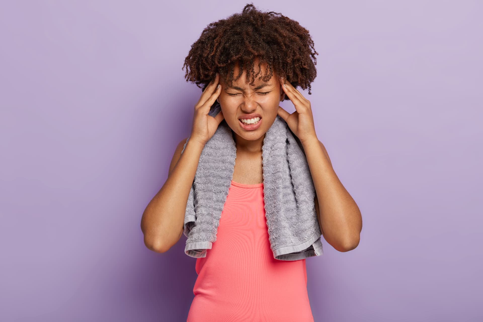 A woman holding her temples, showing signs of pain or distress