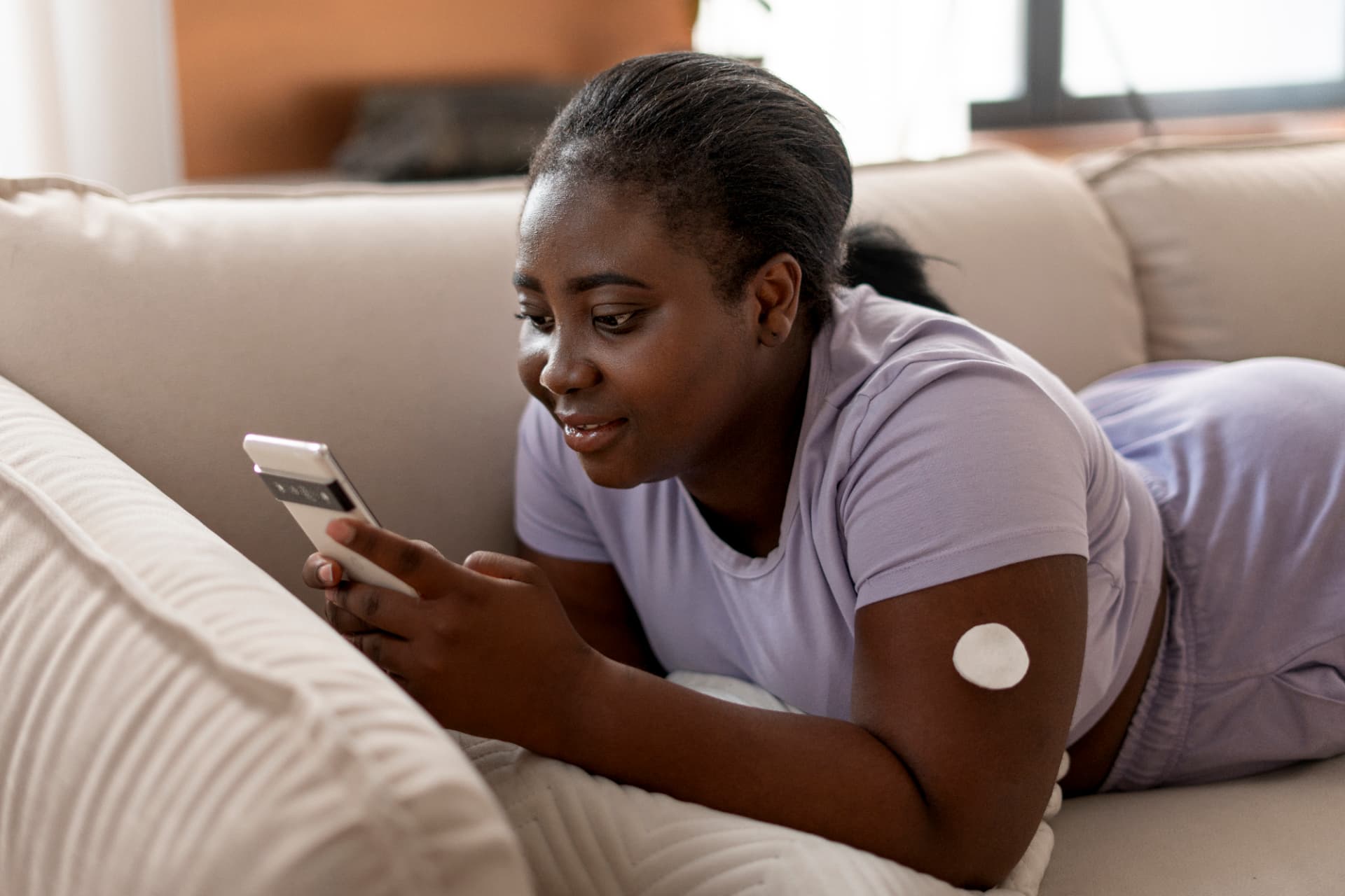 A person checking their health information on a phone in a relaxed home setting